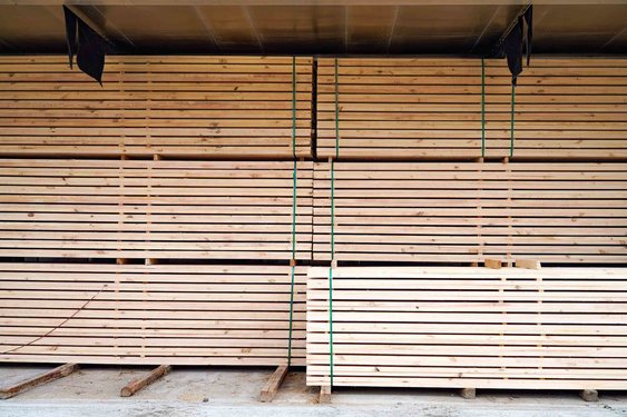 Gestapelte Holzstaffeln in einer Halle